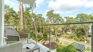 A balcony with outdoor furniture, a view of a residential area, and a road. - Comfortable apartment by the sea (Pobierowo)