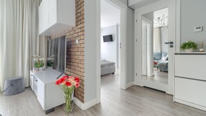 A modern kitchen with a brick accent wall, a white countertop, and a vase of flowers. - Comfortable apartment by the sea (Pobierowo)