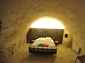 A cozy, arched bedroom with a bed, bedside table, and a small window. - La graineterie (Pont-sur-Yonne)