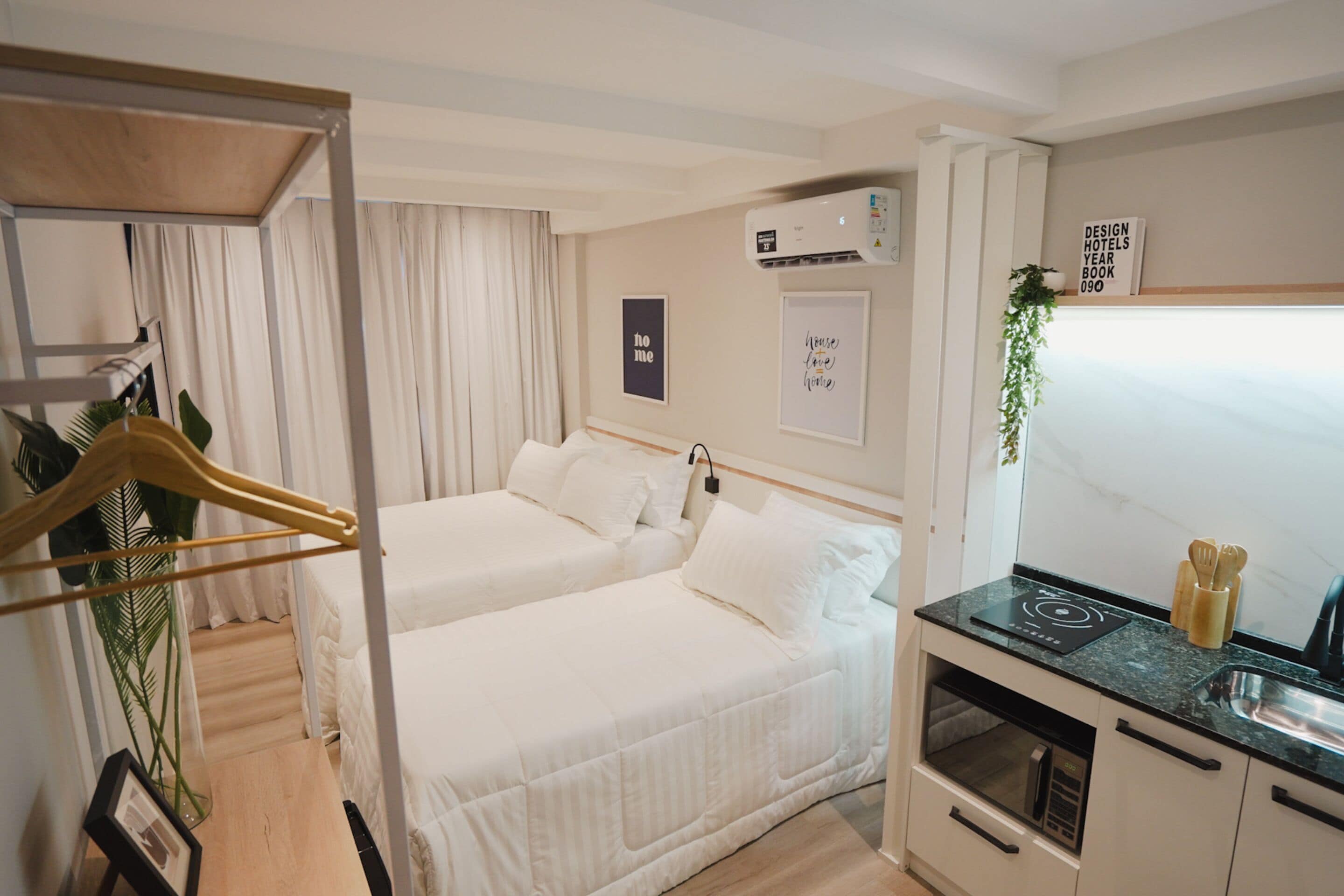 Habitación de hotel con dos camas, kitchenette, un pequeño comedor y vistas a la ciudad.