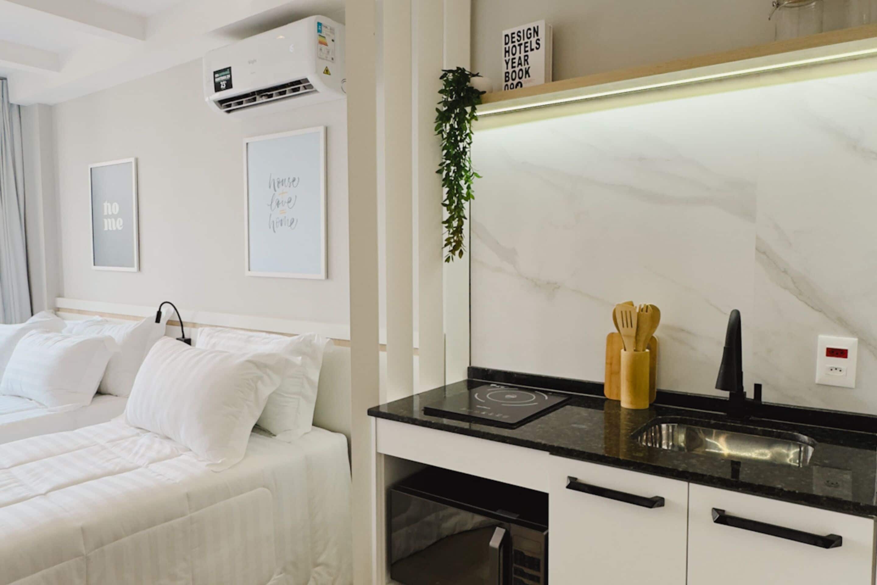 Une chambre d’hôtel moderne équipée d’un lit, d’un bureau intégré avec un lavabo et d’un pare-feu en marbre.