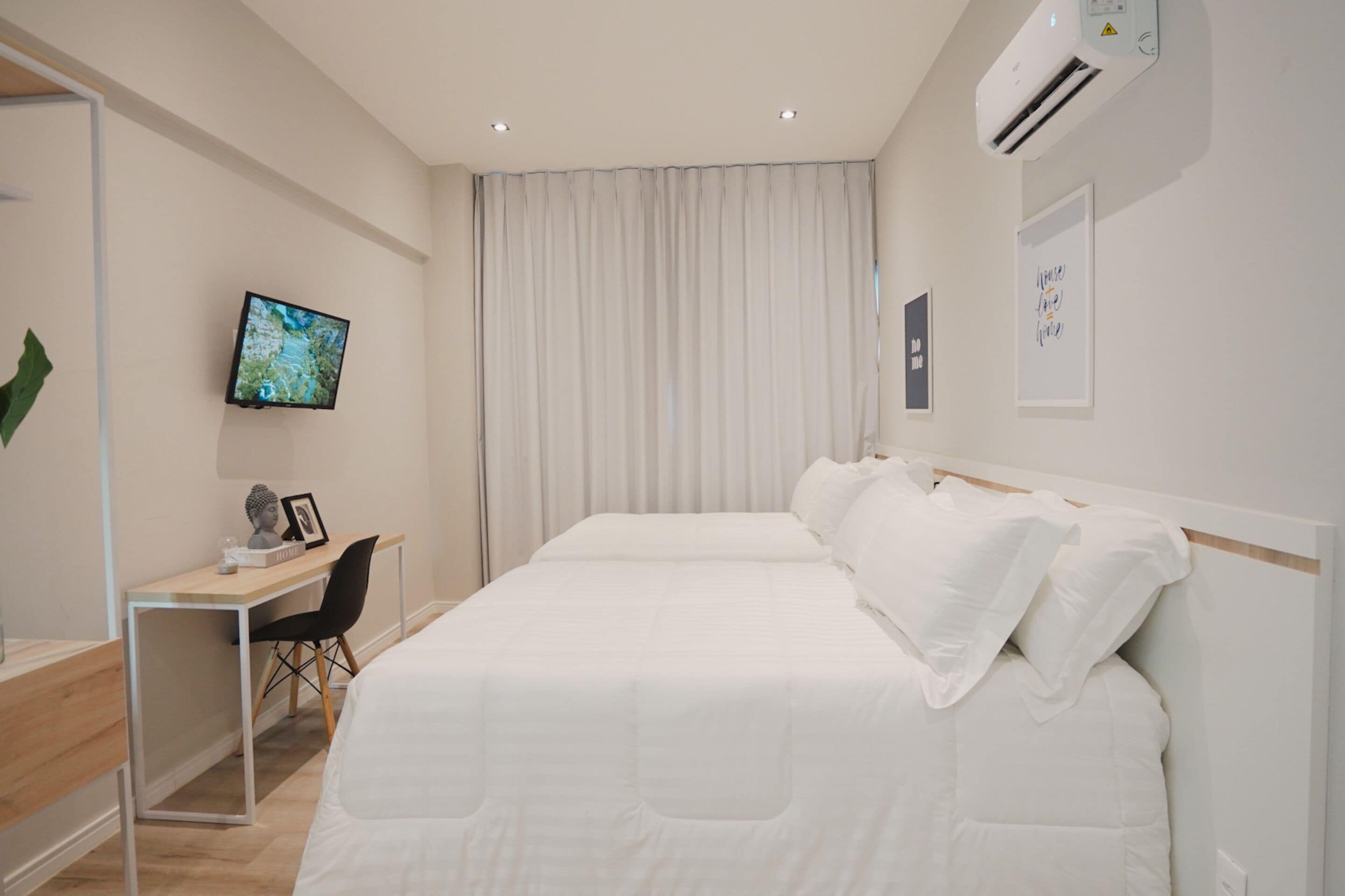 Une chambre d’hôtel moderne dotée d’un grand lit, d’un bureau avec une chaise, d’une télévision à écran plat et d’un système de climatisation.