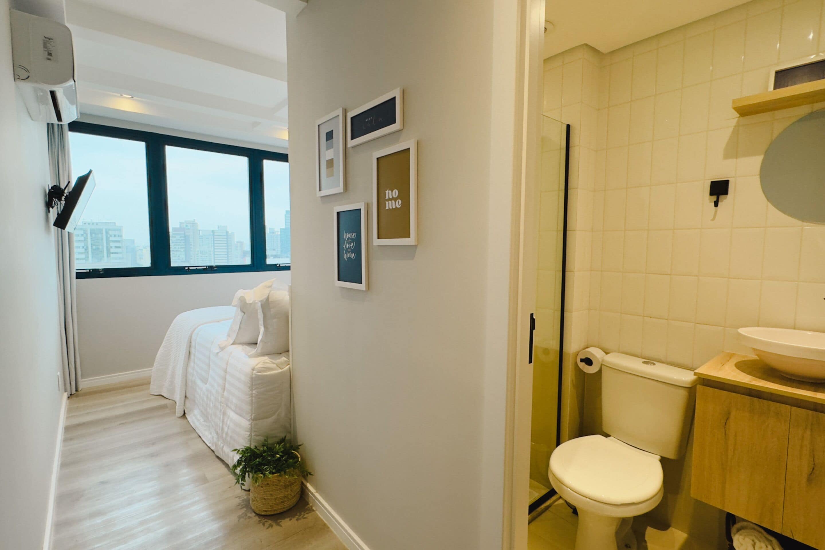 A modern bathroom with a toilet, sink, and a window.