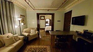 Uma sala de estar com sofá, mesa de centro, TV e um espaço de jantar com mesa e cadeiras.