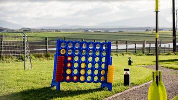 Un tablero azul y amarillo con una valla metálica y un campo de césped al fondo.