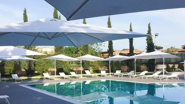 A swimming pool with lounge chairs and umbrellas, surrounded by greenery. - villa maria park (Albano Laziale)