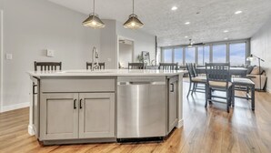 A spacious kitchen with a central island, stainless steel appliances, and pendant lighting. - Good Vibes Only in the Stillwater at Bridges Bay Resort (Arnolds Park)