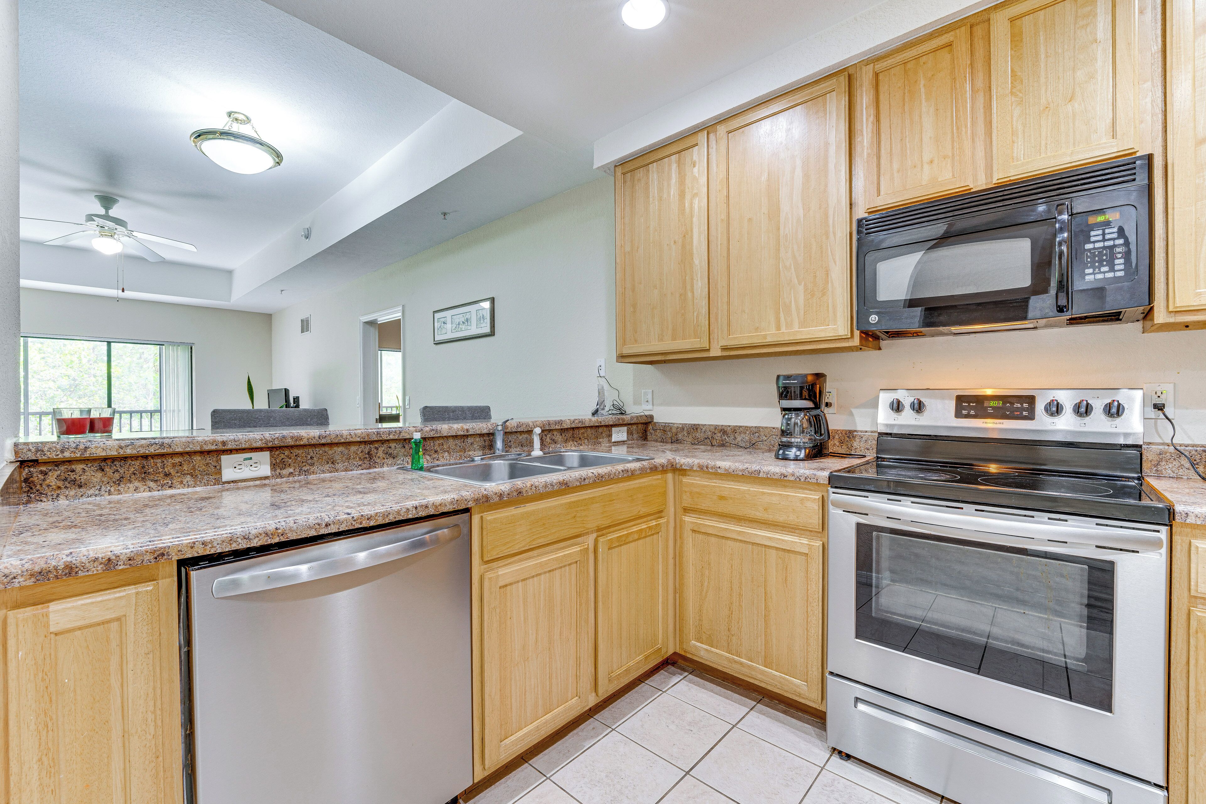 A kitchen with wooden cabinets, a stainless steel dishwasher, a microwave, and an oven.