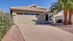 A residential house with a garage, a driveway, and a palm tree. - Golf Course View! Dog-friendly Retreat in Glendale (Glendale)