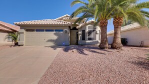 A residential house with a garage, palm trees, and a gravel driveway. - Golf Course View! Dog-friendly Retreat in Glendale (Glendale)