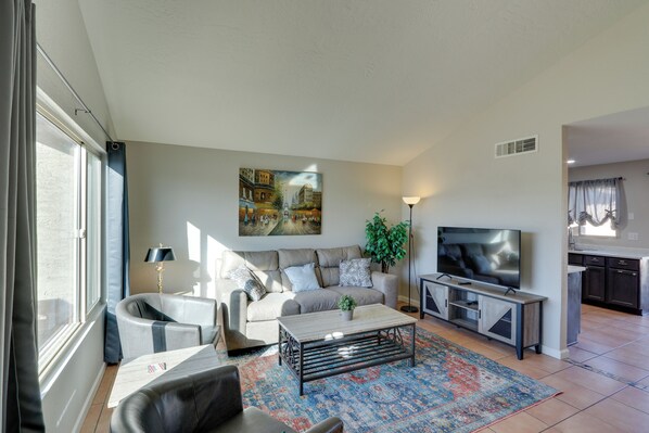 A modern living room with a sofa, armchairs, a coffee table, a TV, and a painting on the wall. - Pool, Game Room! Golfer's Paradise in Mesa (Mesa)