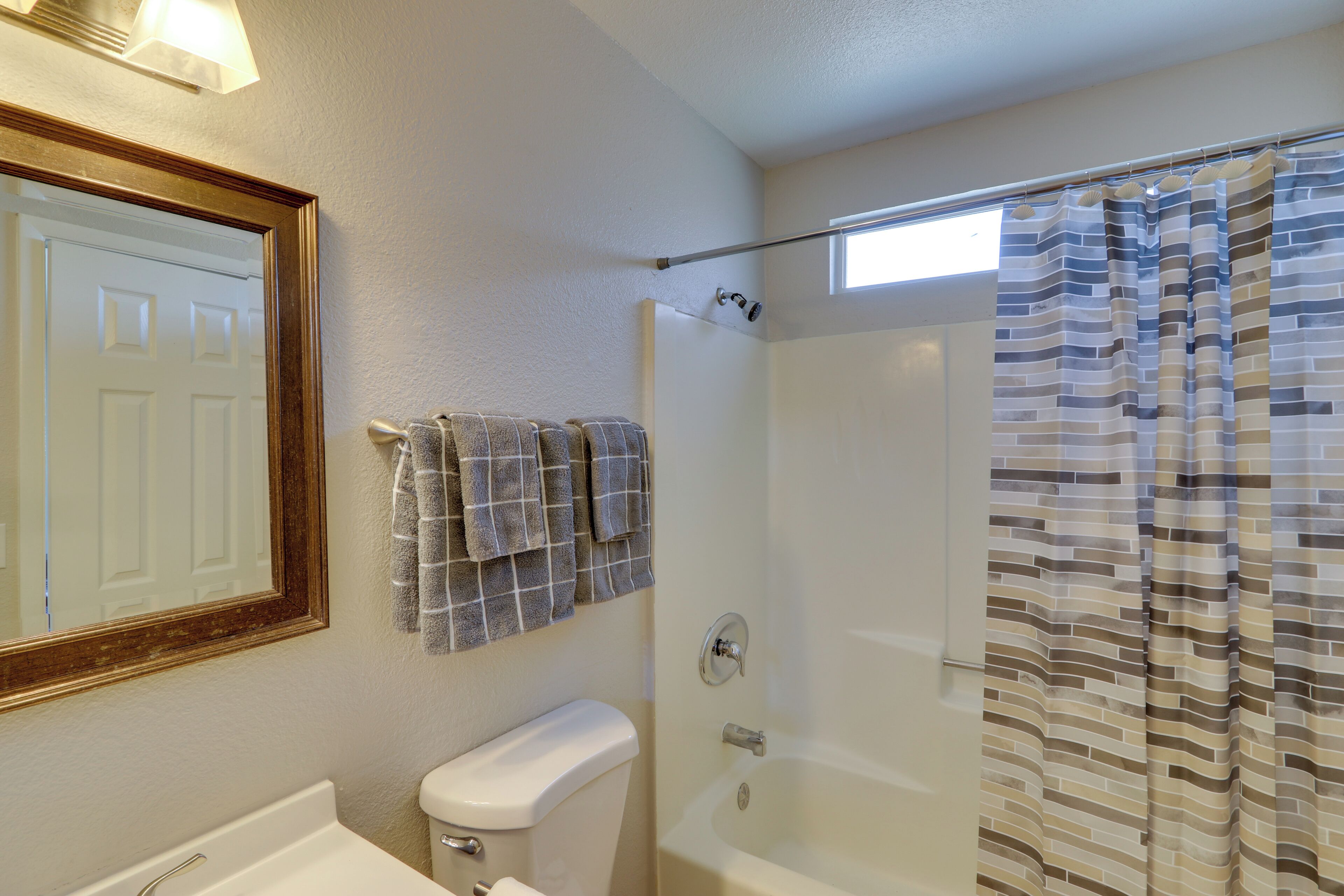 A bathroom with a toilet, sink, and shower.