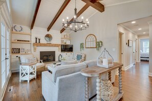 Cozy living area with a high ceiling, fireplace, and comfortable seating.