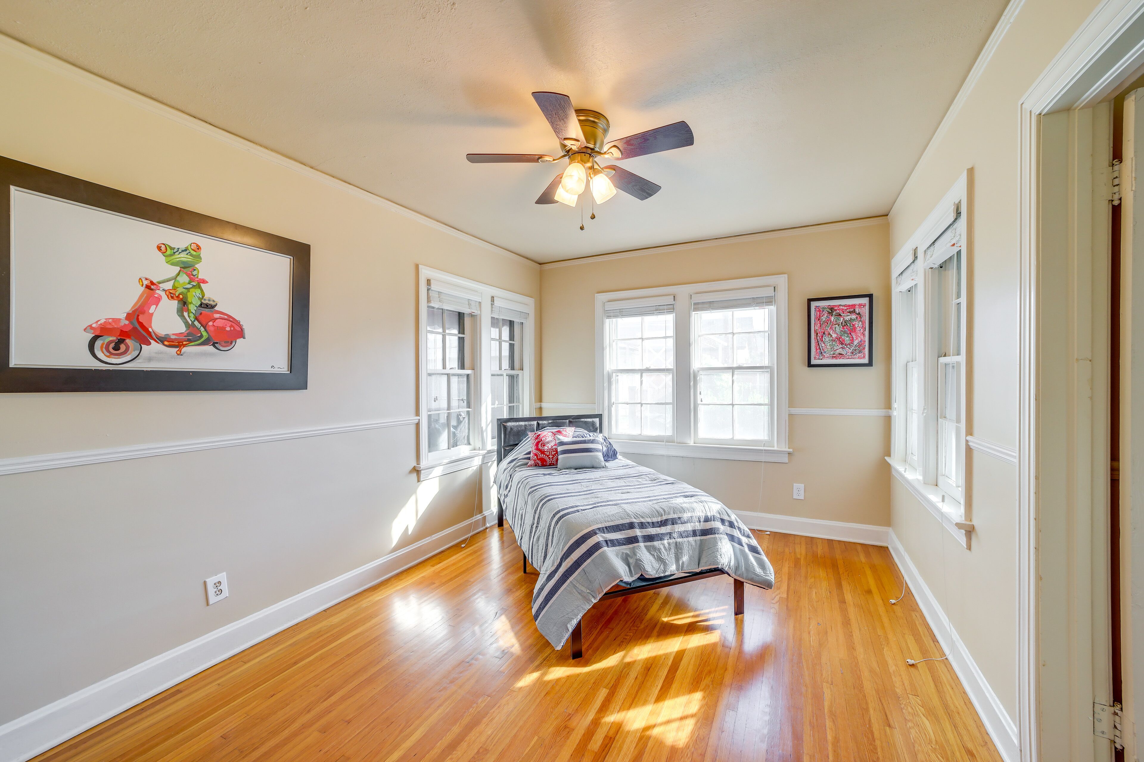 Quarto com cama, ventilador de teto e janela.