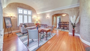 Un salon spacieux doté d’un parquet, d’un canapé, d’une table basse et d’un coin repas avec une table et des chaises.