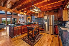 Une cuisine spacieuse avec des meubles en bois, un grand îlot central et des appareils électroménagers en acier inoxydable.