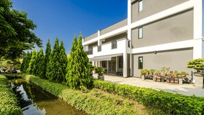A modern building with a water feature and greenery. - L.M.S B&B GLAMPING (Gongguan)
