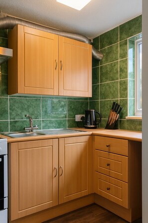 A kitchen with wooden cabinets, a sink, a coffee maker, and a window. - Botanic Gardens Oasis: Urban Convenience & Comfort (Liverpool)