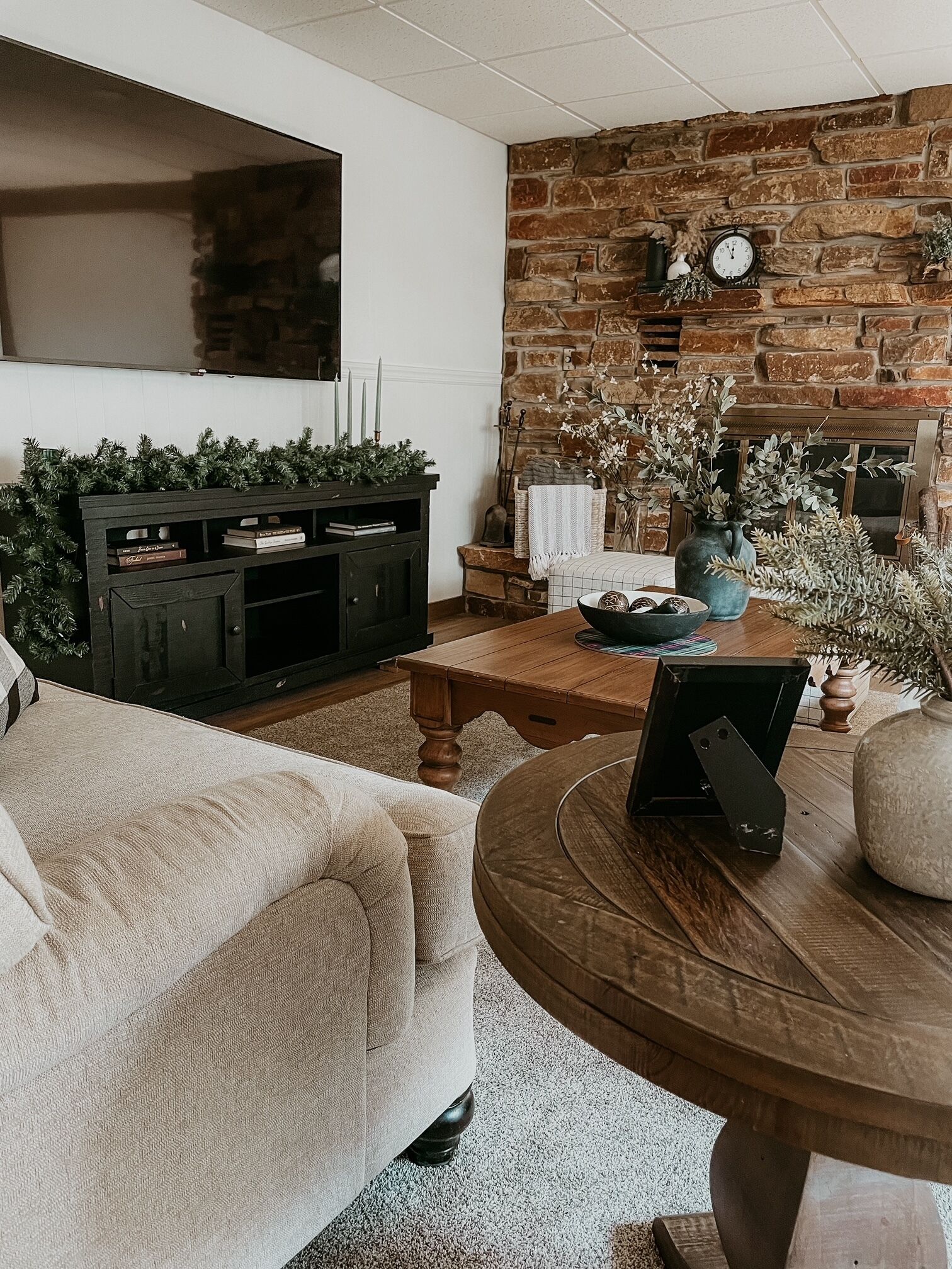 Ein gemütliches Wohnzimmer mit Kamin, Wandfernseher und bequemer Couch.