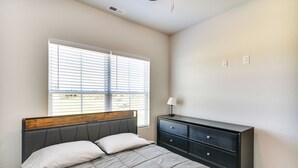 A bedroom with a bed, a dresser, and a window with blinds. - Cape Charles Home: 4 Mi to Kiptopeke State Park! (Cape Charles)