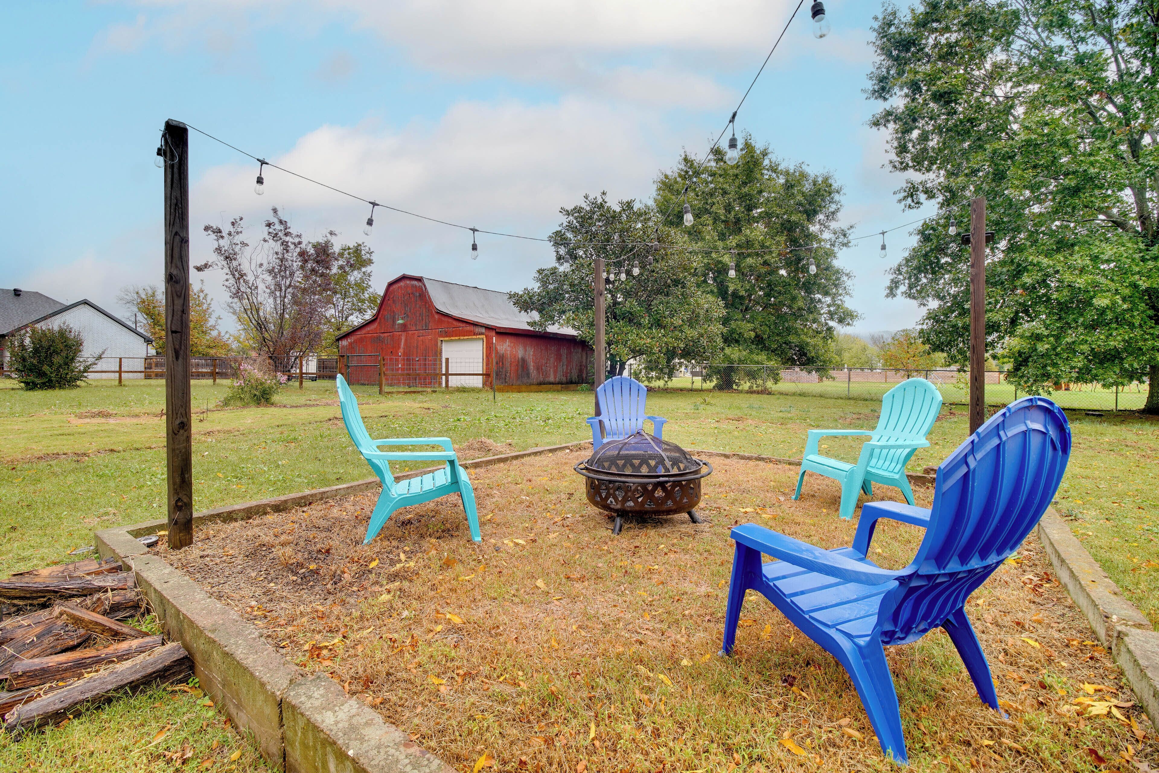An outdoor seating area with two blue Adirondack chairs and a fire pit.