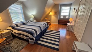 Een slaapkamer met een bed, nachtkastjes, een lamp, een stoel, een kaptafel en een kledingkast.