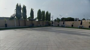 Zona de terrassa a l'exterior amb paviment de rajoles, diverses cadires i ombrel·les.
