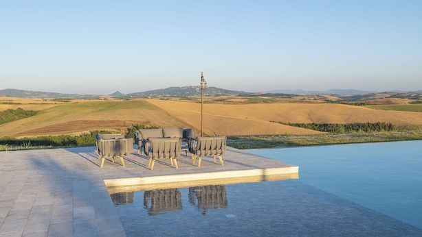 A pool with a view of rolling hills and a distant tower. - Villa Tosca (Peccioli)