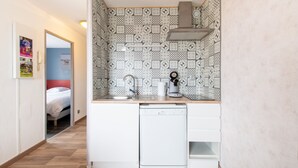 A compact kitchen with a dishwasher, a coffee maker, and a patterned backsplash. - Le Mayflower - One Bedroom Apartment, Sleeps 4 (Le Grau-du-Roi)