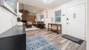 A modern living room with a fireplace, a sofa, a coffee table, and a rug. - Luxury Lakefront Escape, Beach Volleyball, Kayaks, Fire Pit Hot Tub & Game Room! (Hot Springs)