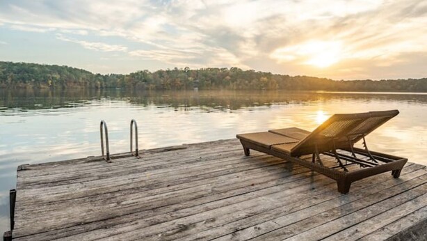 A wooden dock with a lounge chair and metal handrails. - Luxury Lakefront Escape, Beach Volleyball, Kayaks, Fire Pit Hot Tub & Game Room! (Hot Springs)