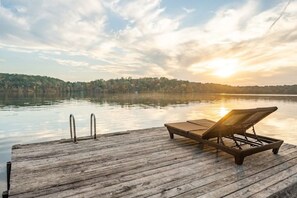 A wooden dock with a lounge chair and metal handrails. - Luxury Lakefront Escape, Beach Volleyball, Kayaks, Fire Pit Hot Tub & Game Room! (Hot Springs)