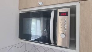 Un four à micro-ondes doté d’un écran numérique, de boutons de commande et d’une porte en verre.