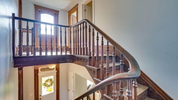 Un escalier en bois à la forme incurvée, menant à l’étage supérieur.