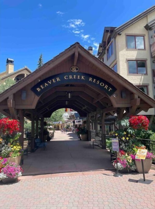 The entrance to Beaver Creek Resort with a covered walkway and flower arrangements. - Eagle River Retreat (Avon)