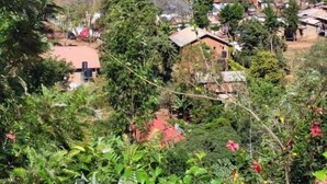 A rural village with scattered houses, a prominent white tower, and dense greenery. - Lushoto Views Cottage (Lushoto)