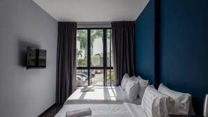 A hotel room with a bed, a TV mounted on the wall, and a window with curtains. - Chariton Hotel Bagan (Butterworth)