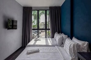 Een hotelkamer met een groot bed, een flatscreen televisie aan de muur en uitzicht op het omliggende landschap.