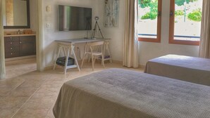 A bedroom with a bed, a desk with a chair, a television, and a window with curtains. - 2-bed Designer Apartment Sleeps 4, Resort Pool (Lowlands)