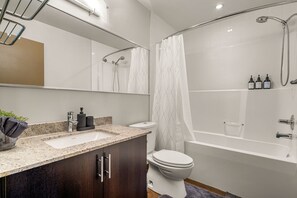 Un baño moderno con una bañera independiente, zona de ducha separada, tocador con lavabo e inodoro.
