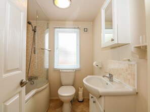Ein kleines, kompaktes Badezimmer mit Dusche, Toilette und Waschbecken.