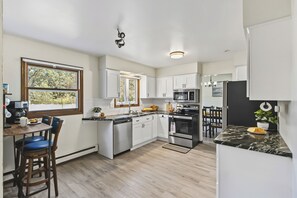 A modern kitchen with white cabinetry, a built-in microwave, and a central island with seating.