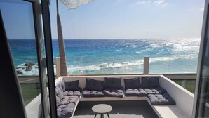 A balcony with a sectional sofa and a small table, overlooking the ocean. - Seaview Resort Boca Sami (Sint Michiel)