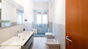Une salle de bain moderne avec un grand lavabo, un bidet et des toilettes.