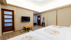 A hotel room with a bed, a television, a small table, and a door. - Family friendly
Pets friendly  (Taitung County)