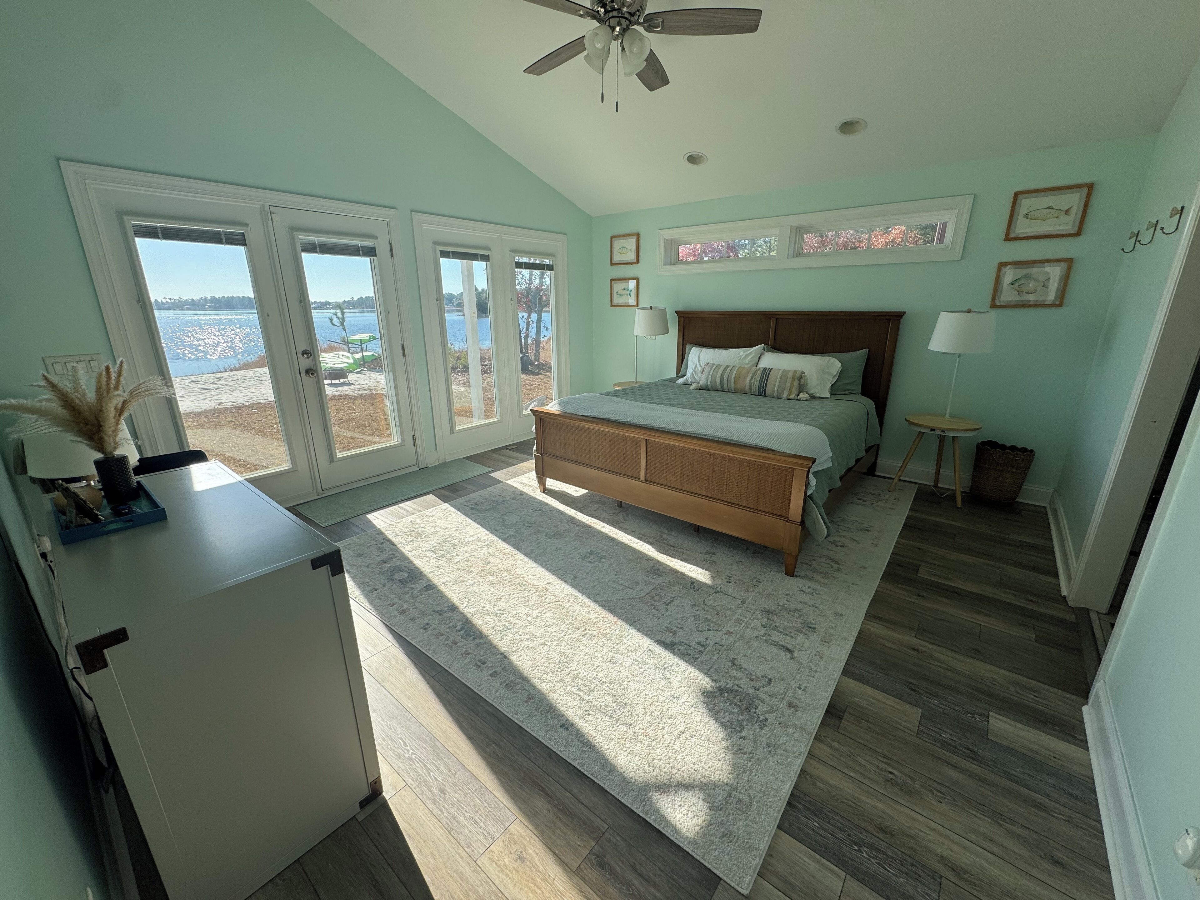 Une chambre avec un grand lit, un bureau et une vue sur l’extérieur.