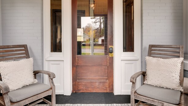 A wooden door with a glass panel, flanked by two wooden chairs with cushions. - Spacious Home in Ramsay: 9 Smart TVs + Pool Table! (Ramsay)