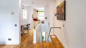 Un intérieur moderne avec un escalier menant à une salle à manger et à une cuisine.