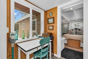 2 habitaciones, escritorio y tabla de planchar con plancha