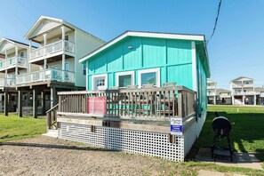 A two-story building with a balcony, a grill, and a sign indicating a rental property. - Steps to Sand Renovated Surfside Beach House (Surfside Beach)